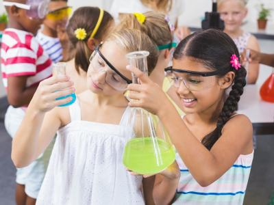Two girls holding science beakers.