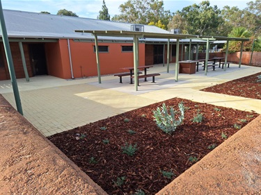 Courtyard showing newly planted garden beds barbecue and undercover picnic seating at the rear of the centre