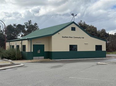 External of Southern River Hall showing green roof cream walls and a portion of the car park