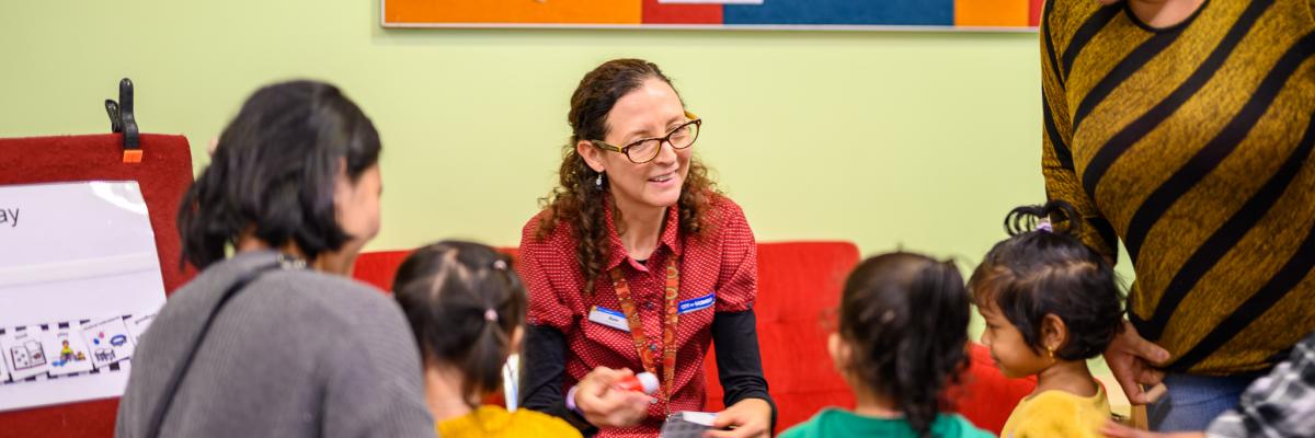 Image of library staff member interacting with children