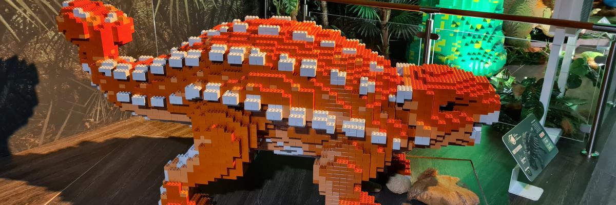A LEGO statue of an orange ankylosaurus dinosaur.