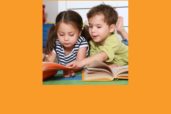 Two toddlers looking at books