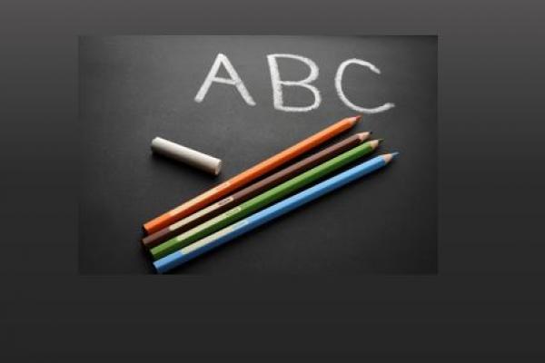 ABC written in chalk with four coloured pencils