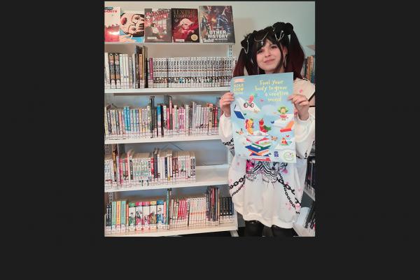 Deboria Gregoria in front of library manga shelves