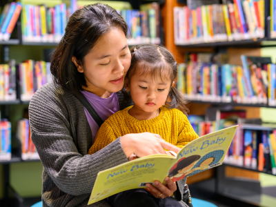 A mother and child reads a story in the library