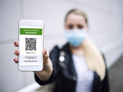 Person holding smartphone displaying COVID certificate