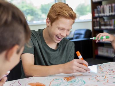 Teen drawing on whiteboard in library