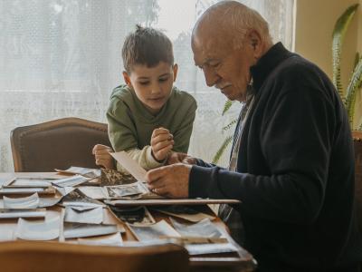 Senior man showing his grandson photos