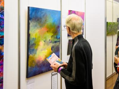 Man viewing colourful artwork at the 2022 Community Art Exhibition and Awards