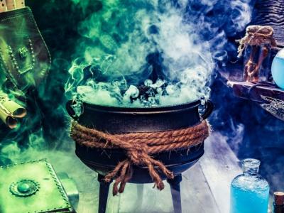 Cauldron, bubbling and steaming, scrolls and beakers in a dark room.